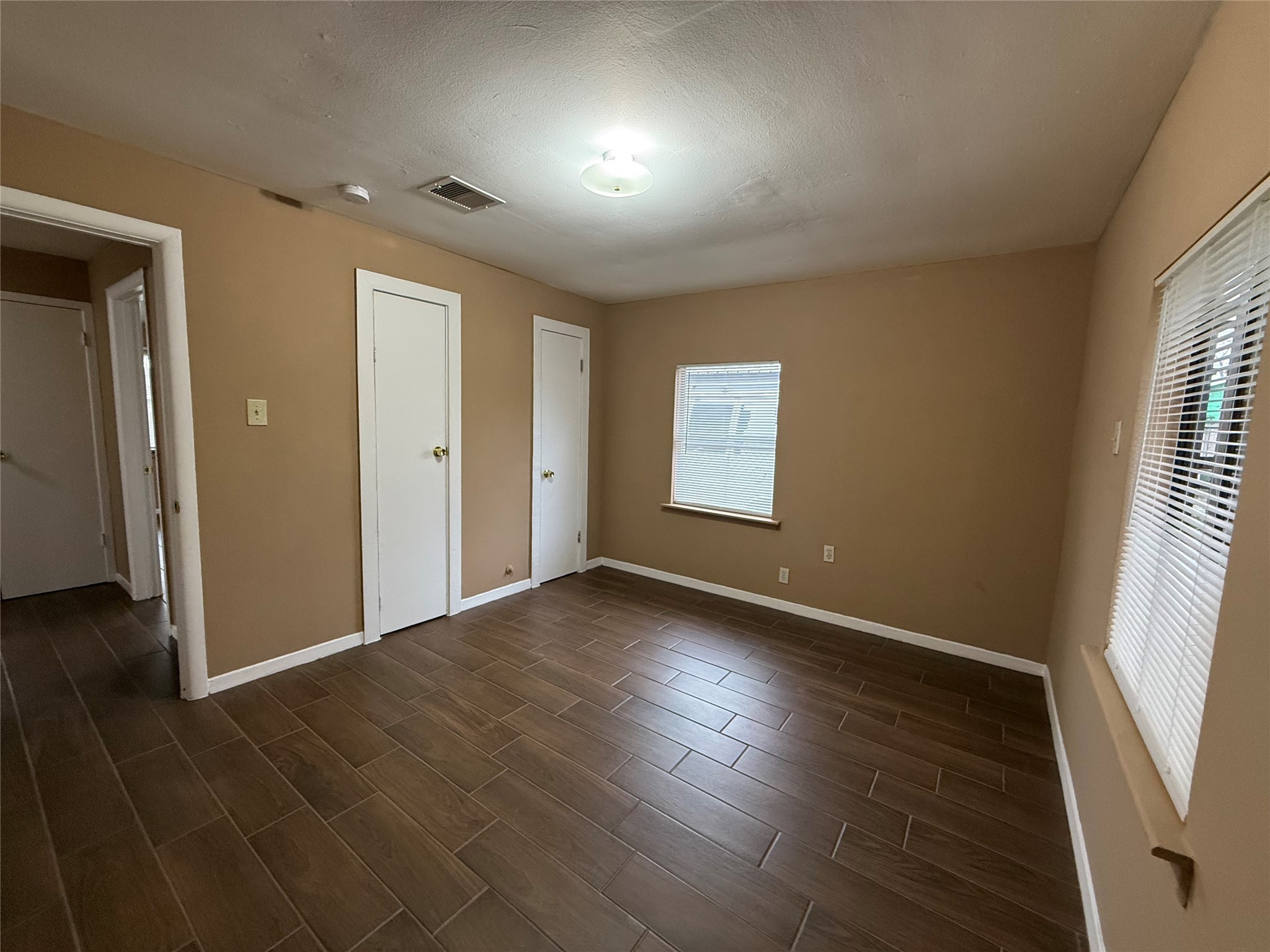 11216 Rusty Street Houston, TX 77093 - Photo 4 of 18 an empty room with wooden floor and windows