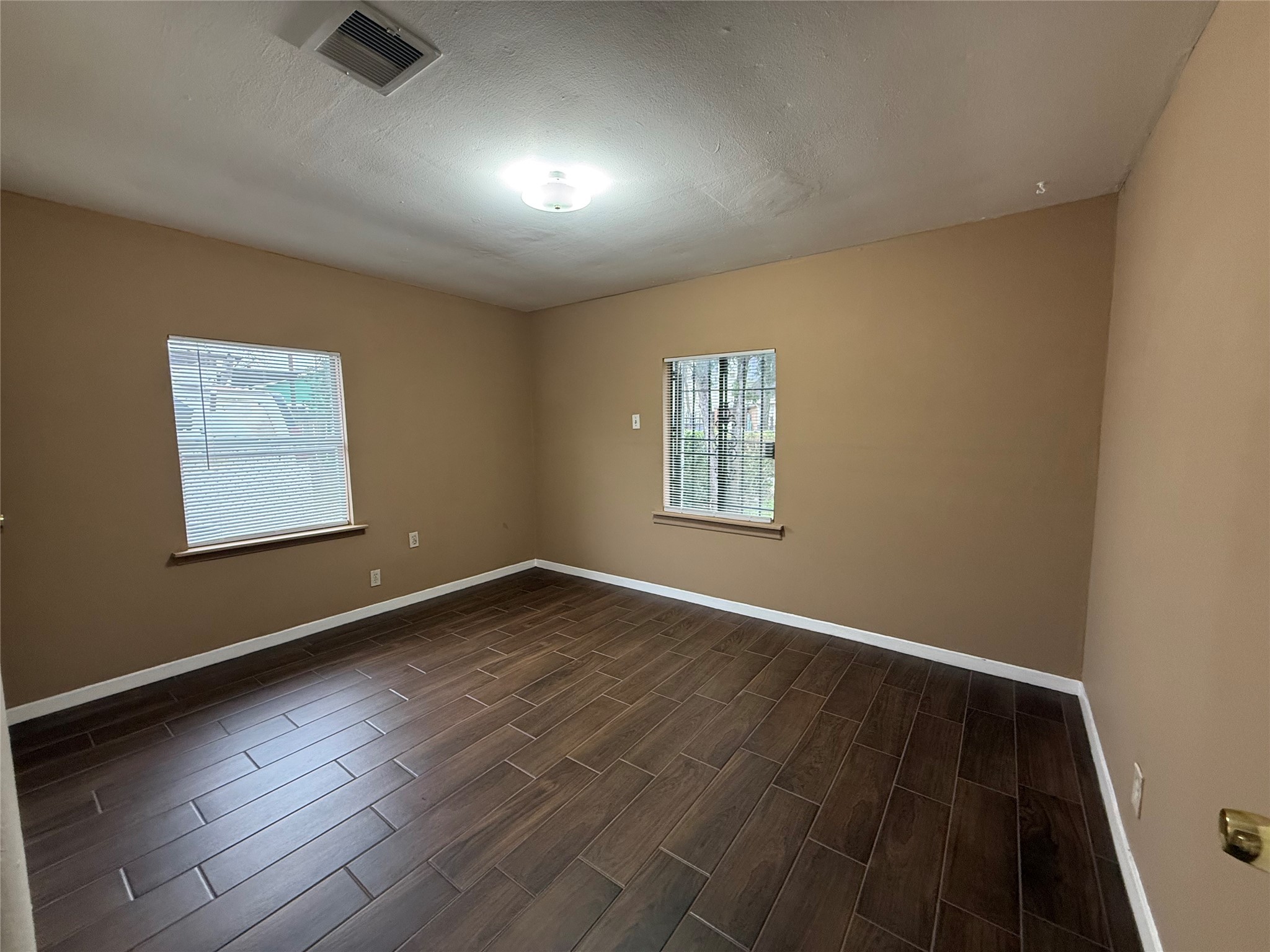 11216 Rusty Street Houston, TX 77093 - Photo 5 of 18 an empty room with wooden floor and windows