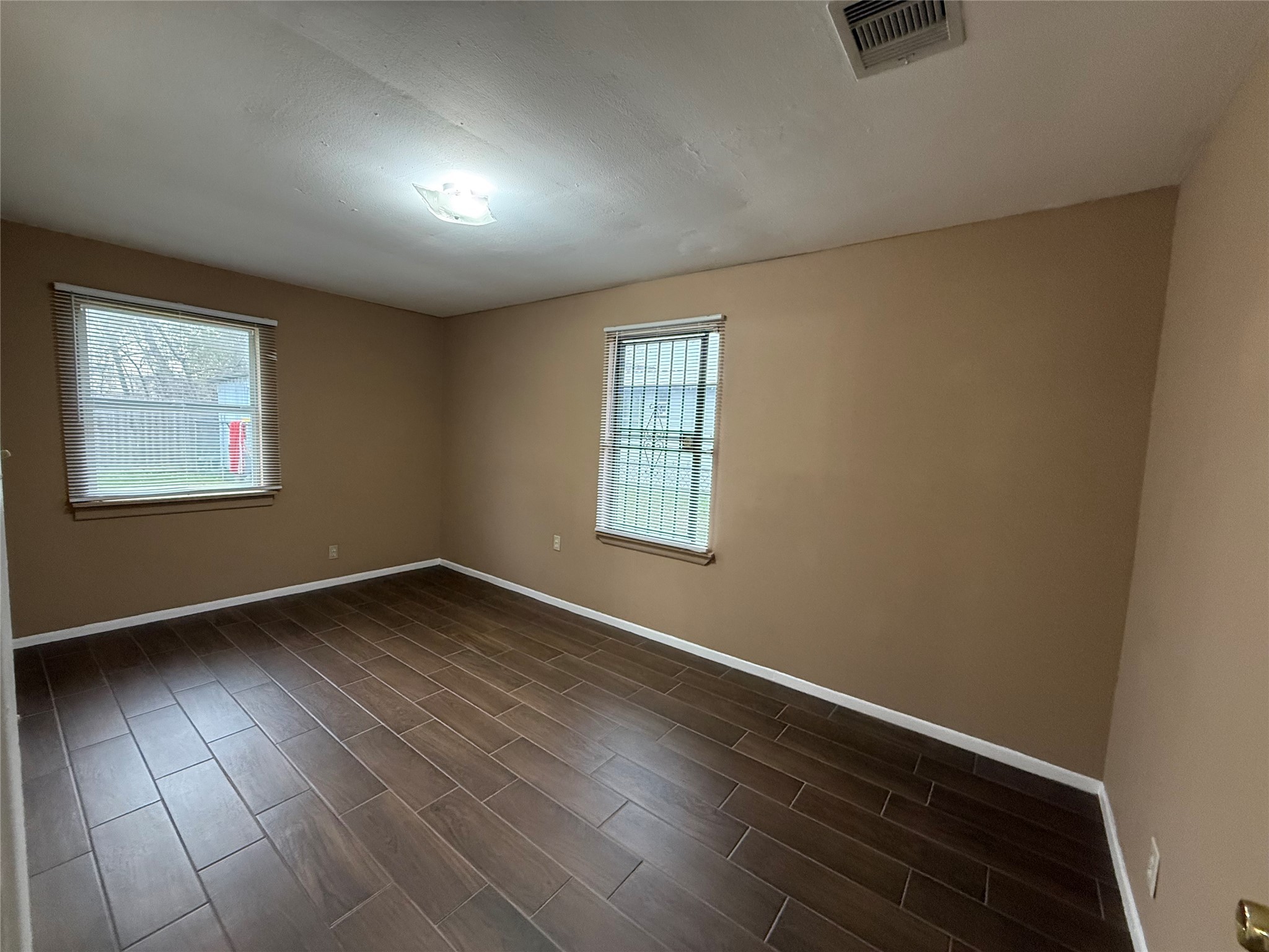 11216 Rusty Street Houston, TX 77093 - Photo 6 of 18 an empty room with wooden floor and windows