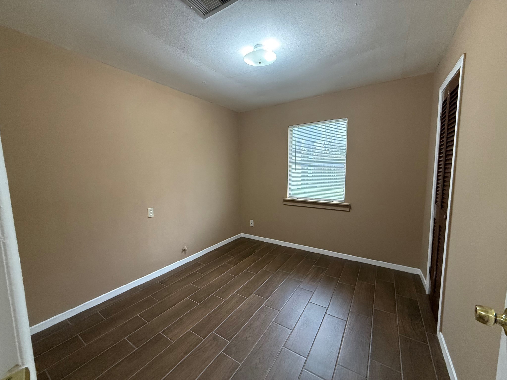 11216 Rusty Street Houston, TX 77093 - Photo 7 of 18 an empty room with wooden floor and windows