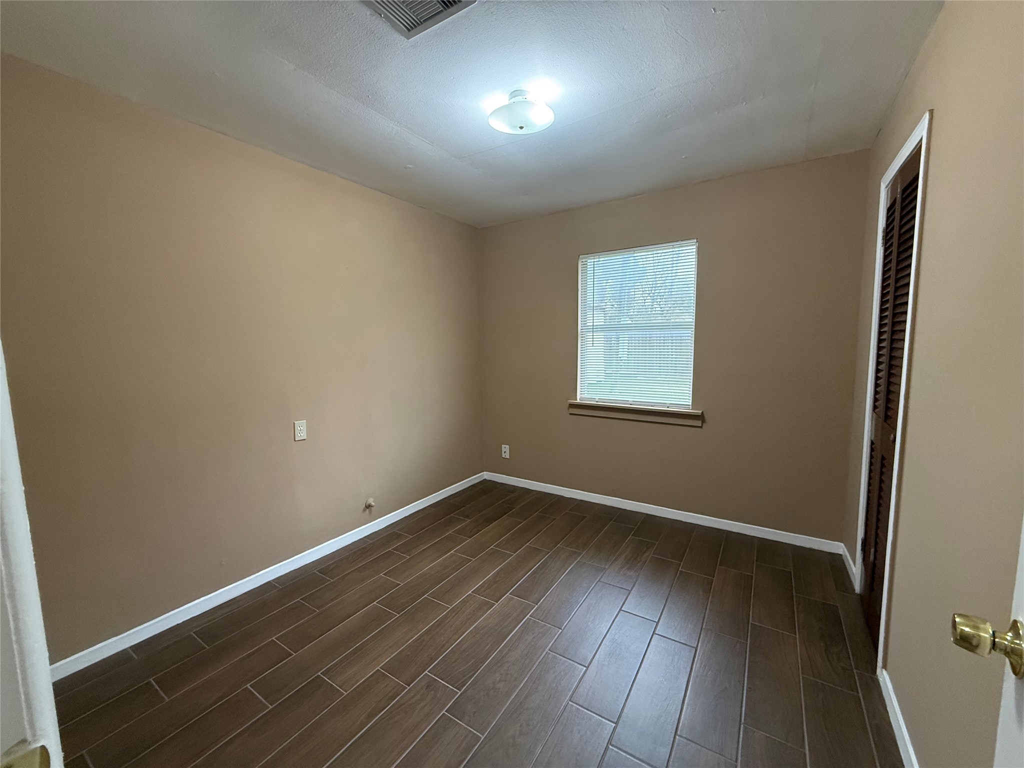 11216 Rusty Street Houston, TX 77093 - Photo 8 of 18 an empty room with wooden floor and windows