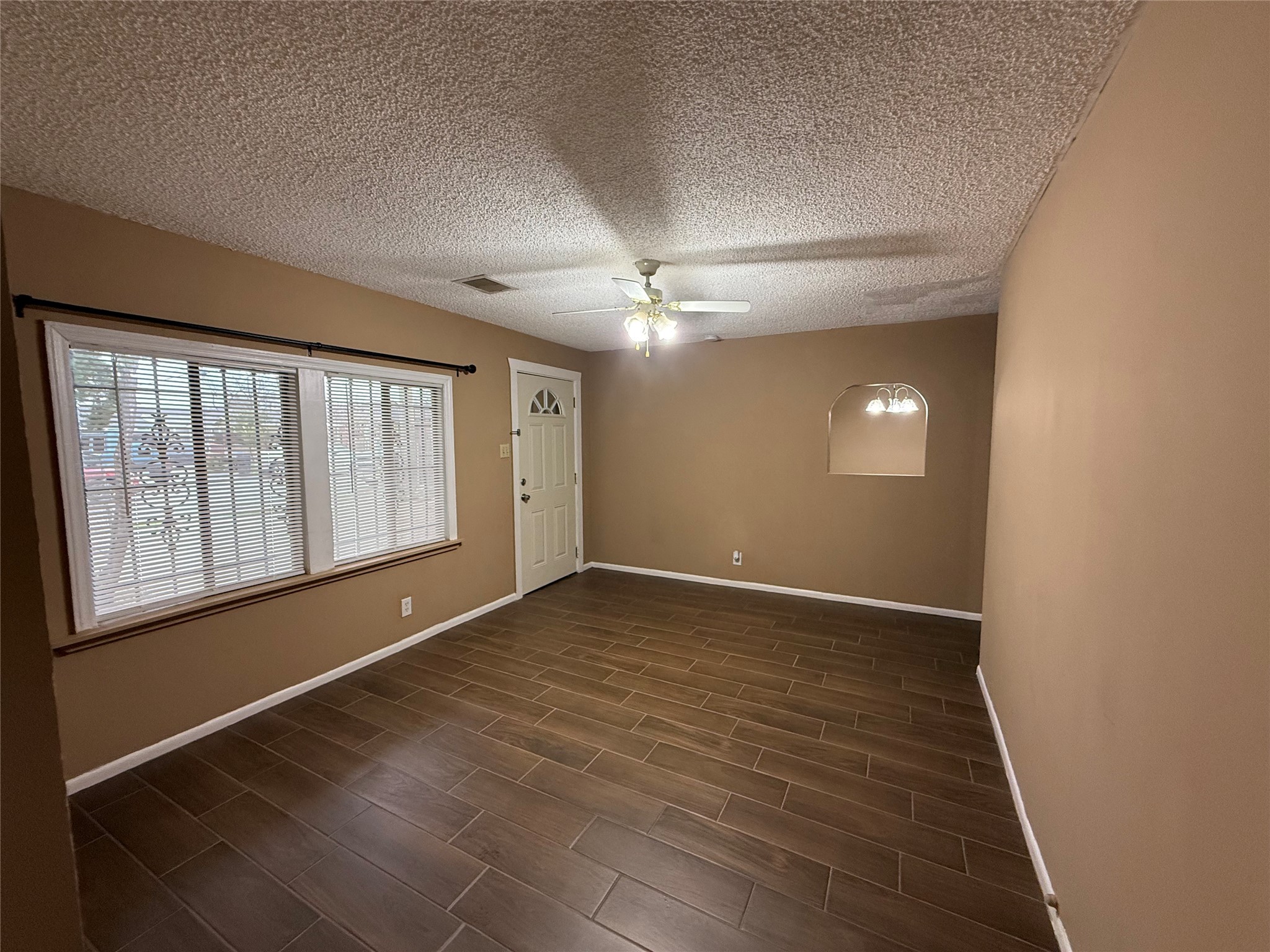 11216 Rusty Street Houston, TX 77093 - Photo 10 of 18 an empty room with wooden floor and windows