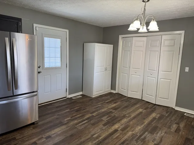 a view of a kitchen with wooden floor and refrigerator and wooden floor