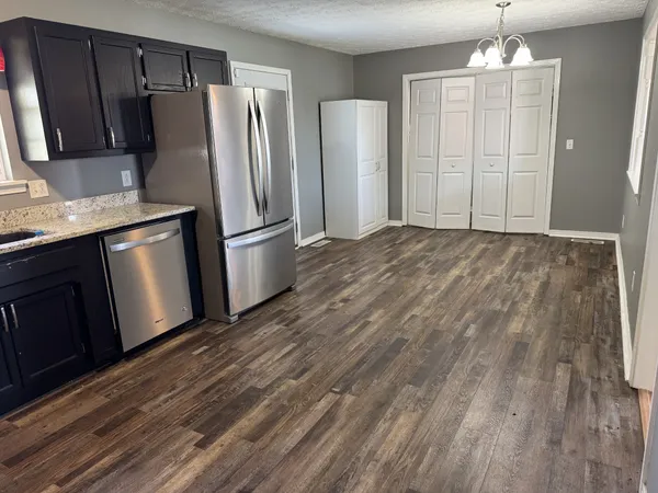 a kitchen with granite countertop a refrigerator and a sink