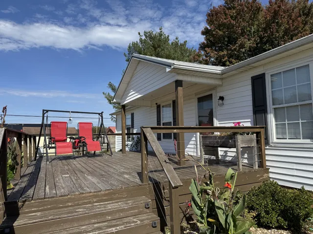 a view of a patio with table and chairs with wooden floor and fence