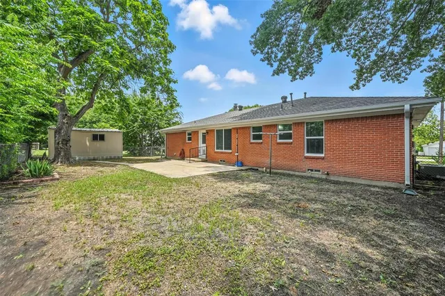 a backyard of a house with plants and tree