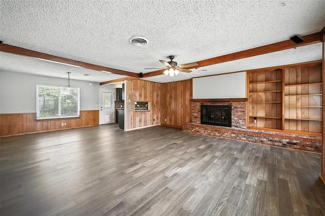 an empty room with windows and fireplace