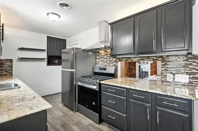 a kitchen with granite countertop stainless steel appliances and wooden cabinets