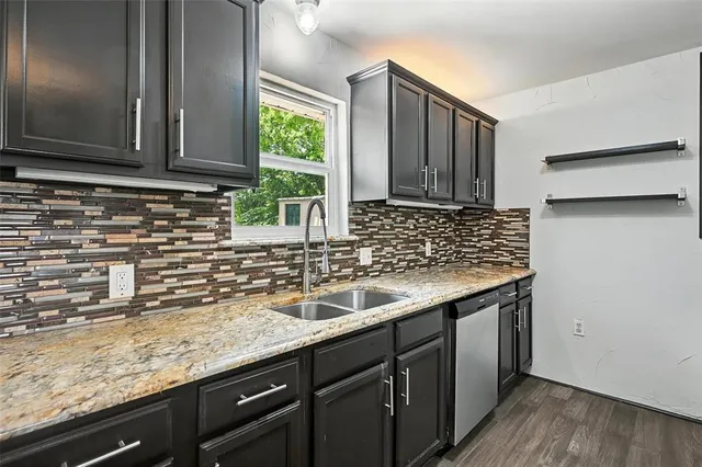 a kitchen with granite countertop a sink and wooden cabinets