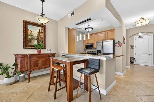 a kitchen with stainless steel appliances kitchen island granite countertop a refrigerator and a stove top oven