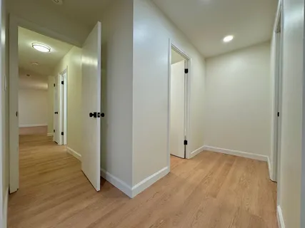 a view of a hallway with wooden floor