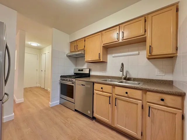 a kitchen with granite countertop a sink stainless steel appliances and cabinets