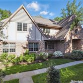 a front view of a house with a garden and plants