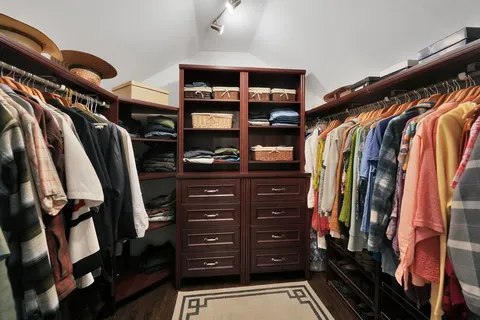 a view of walk in closet with clothes and shoes
