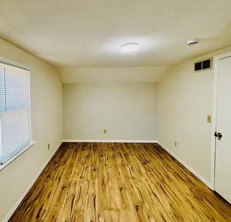 a view of a room with wooden floor and brick walls