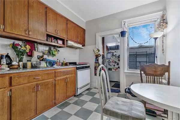 a kitchen with stainless steel appliances granite countertop a dining table chairs and a refrigerator