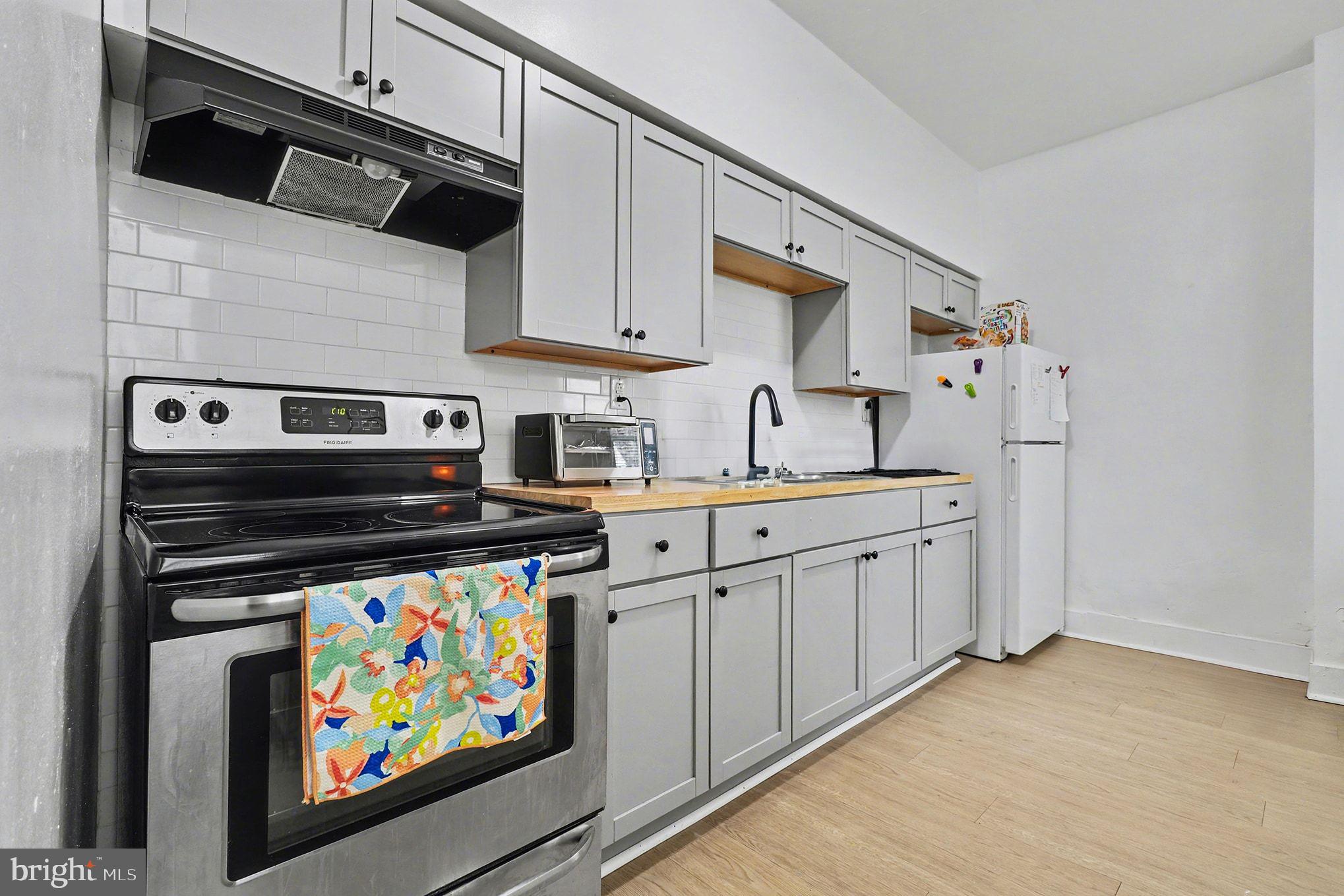 412 Locust Street Lancaster, PA 17602 - Photo 15 of 32 a kitchen with stainless steel appliances a stove a sink and a microwave