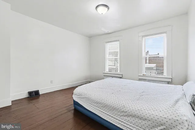 a bedroom with a bed and wooden floor