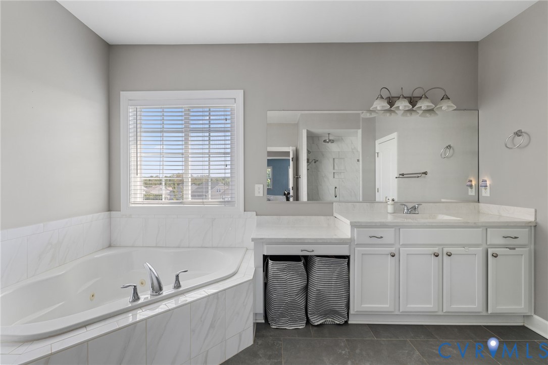 12008 Stable Ridge Terrace Glen Allen, VA 23059 - Photo 20 of 38 a spacious bathroom with a tub sink and mirror