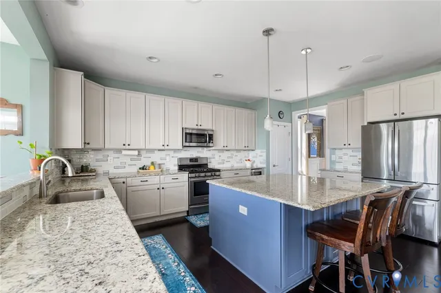 a kitchen with granite countertop a sink a counter top space and living room view