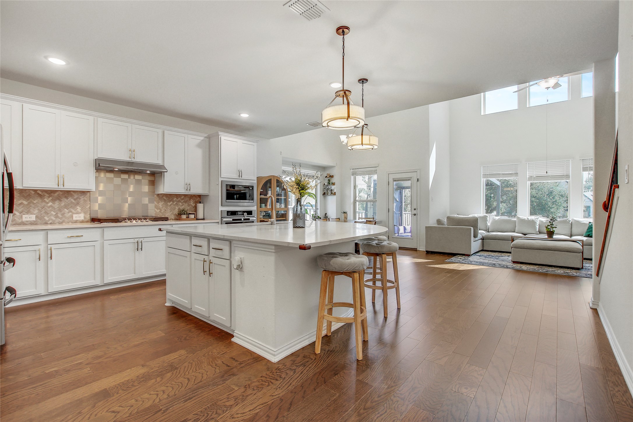 104 Millbend Road Georgetown, TX 78633 - Photo 8 of 40 An open-concept living space integrates a pristine white kitchen with a luminous living area featuring soaring ceilings and ample natural light.