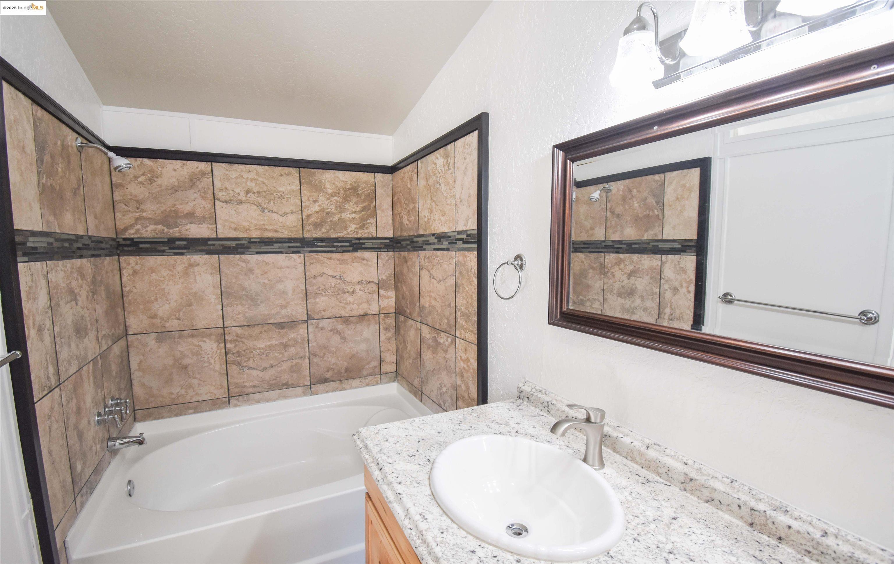 17390 Campbells Flat Road Sonora, CA 95370 - Photo 13 of 37 a bathroom with a granite countertop sink mirror and a bathtub