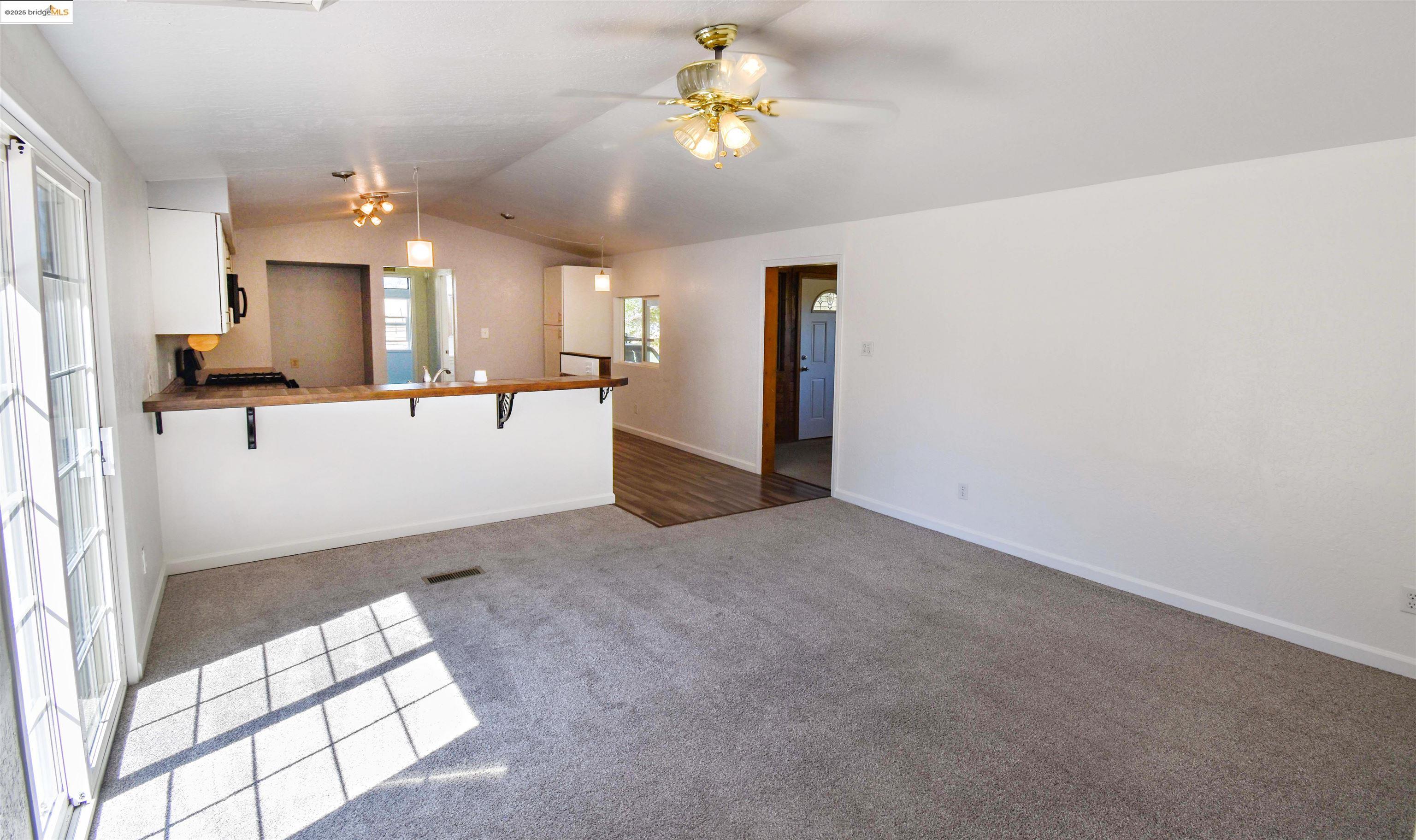 17390 Campbells Flat Road Sonora, CA 95370 - Photo 6 of 37 a view of living room with kitchen island furniture and a chandelier fan
