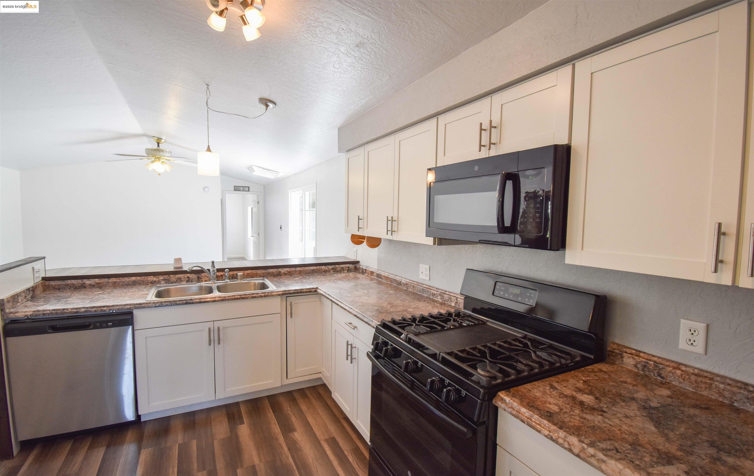 17390 Campbells Flat Road Sonora, CA 95370 - Photo 10 of 37 a kitchen with stainless steel appliances granite countertop a stove a sink and a microwave