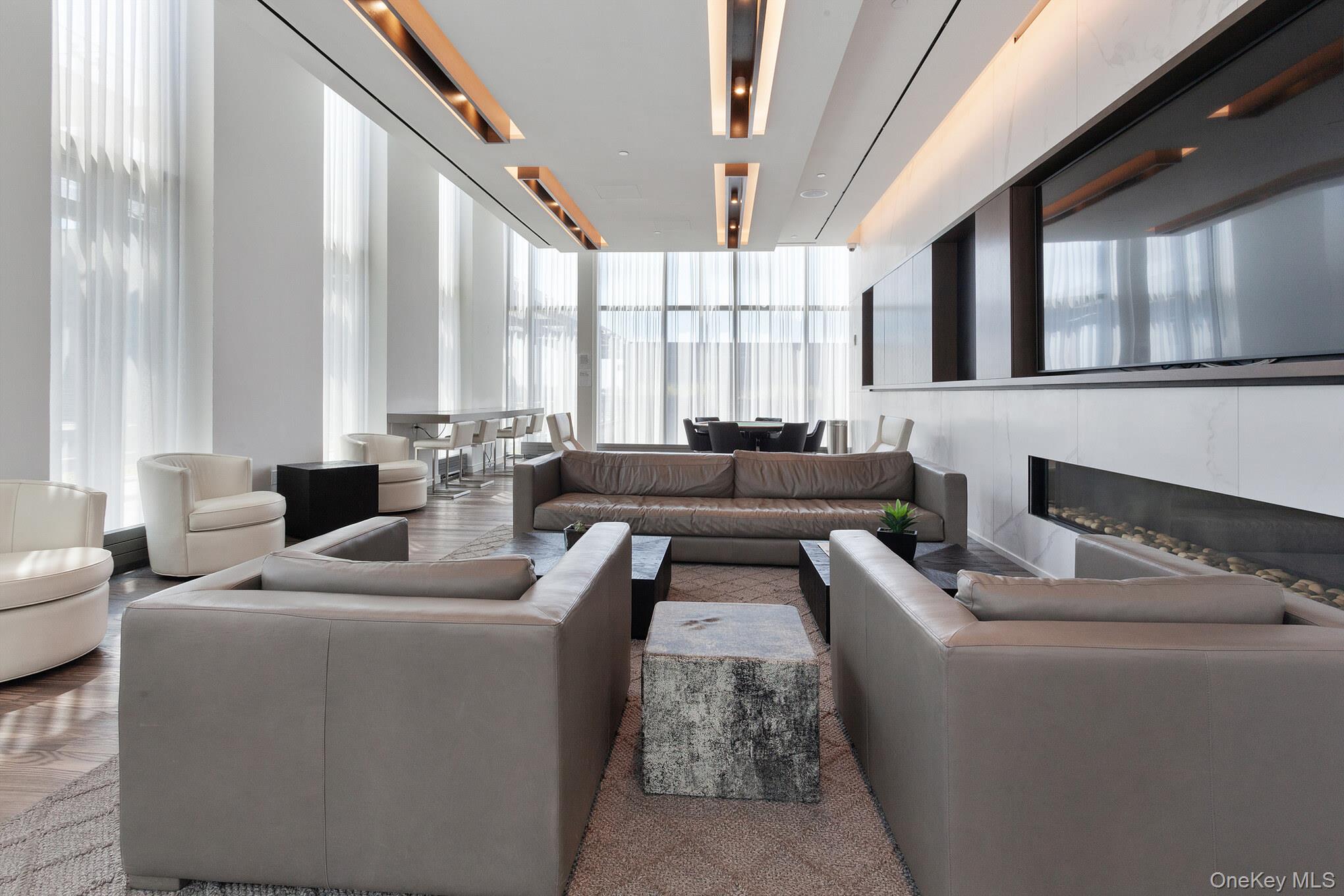 131-01 40 Road, Unit 17S Queens, NY 11354 - Photo 9 of 21 a living room with furniture and large windows