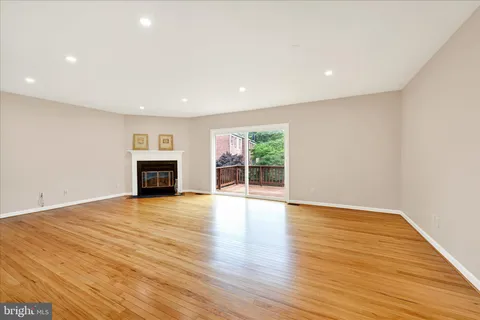 a view of empty room with wooden floor and fireplace