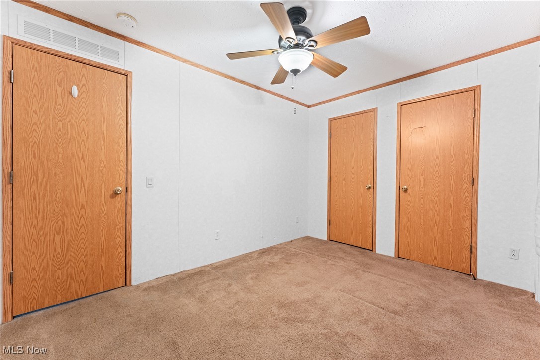 6615 Cleveland Road, Unit K2 Ravenna, OH 44266 - Photo 20 of 24 Unfurnished bedroom featuring ornamental molding, multiple closets, carpet, and ceiling fan