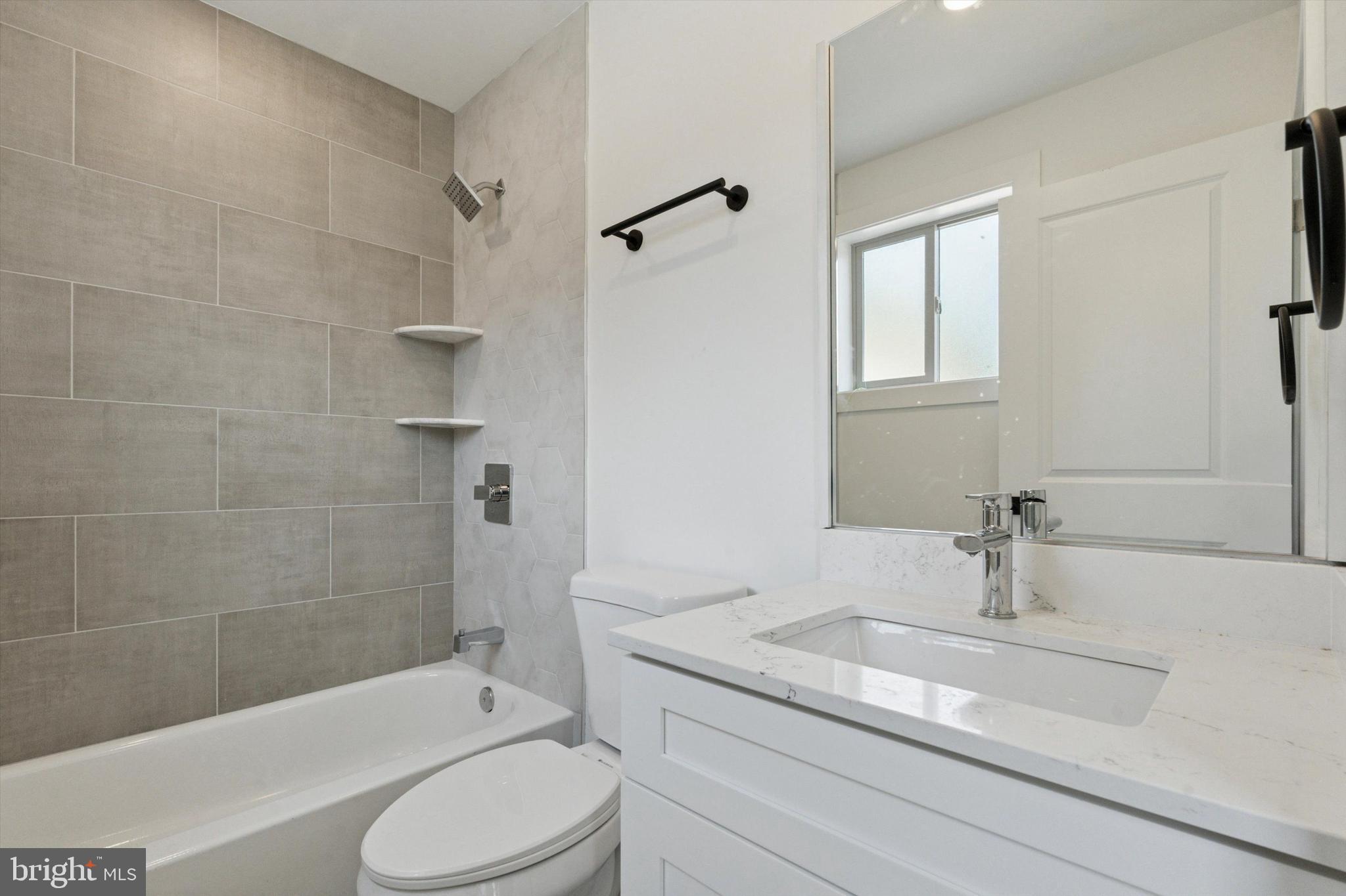 2401 North 2nd Street, Unit E1 Philadelphia, PA 19133 - Photo 10 of 12 a bathroom with a granite countertop sink toilet and shower