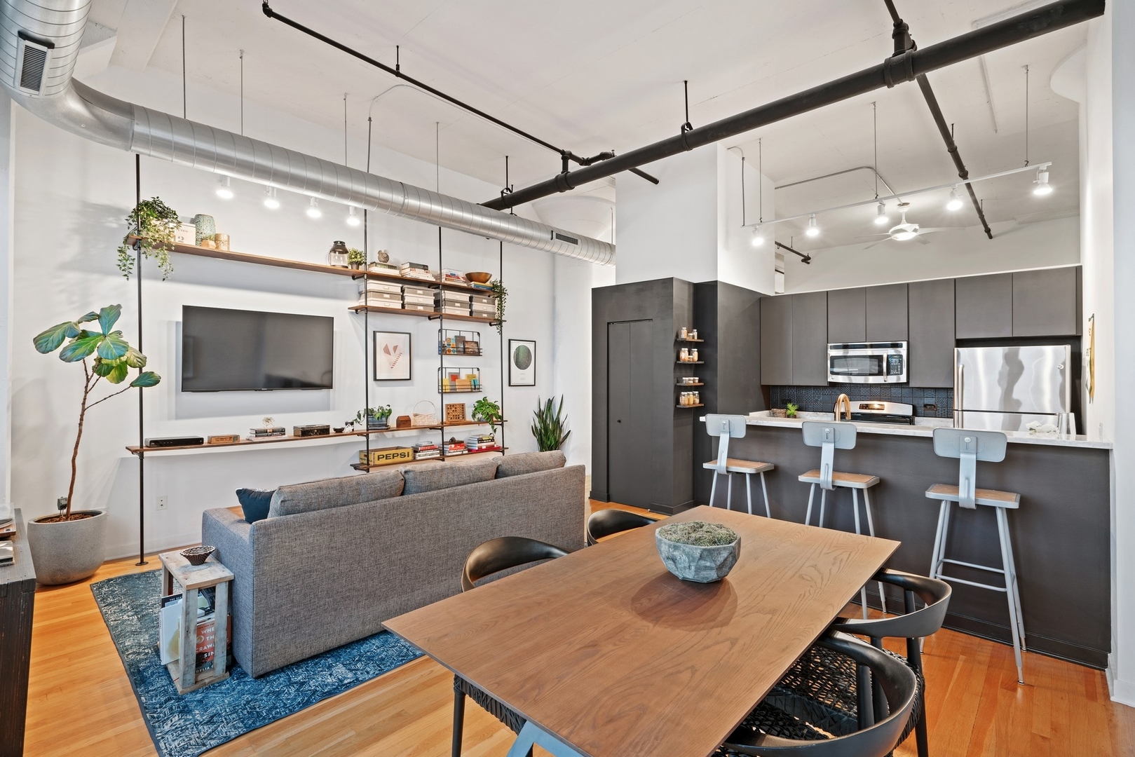 1224 West Van Buren Street, Unit 304 Chicago, IL 60607 - Photo 15 of 28 a kitchen with stainless steel appliances granite countertop a table chairs and a refrigerator