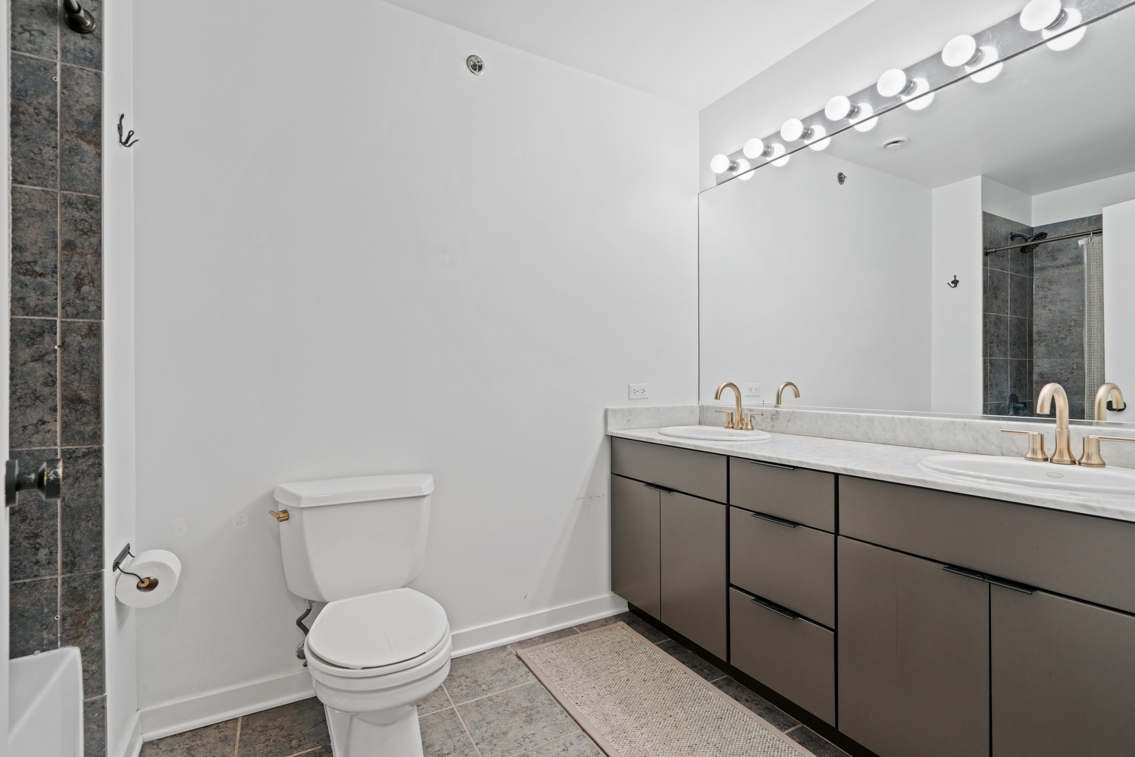 1224 West Van Buren Street, Unit 304 Chicago, IL 60607 - Photo 19 of 28 a bathroom with a toilet sink and mirror