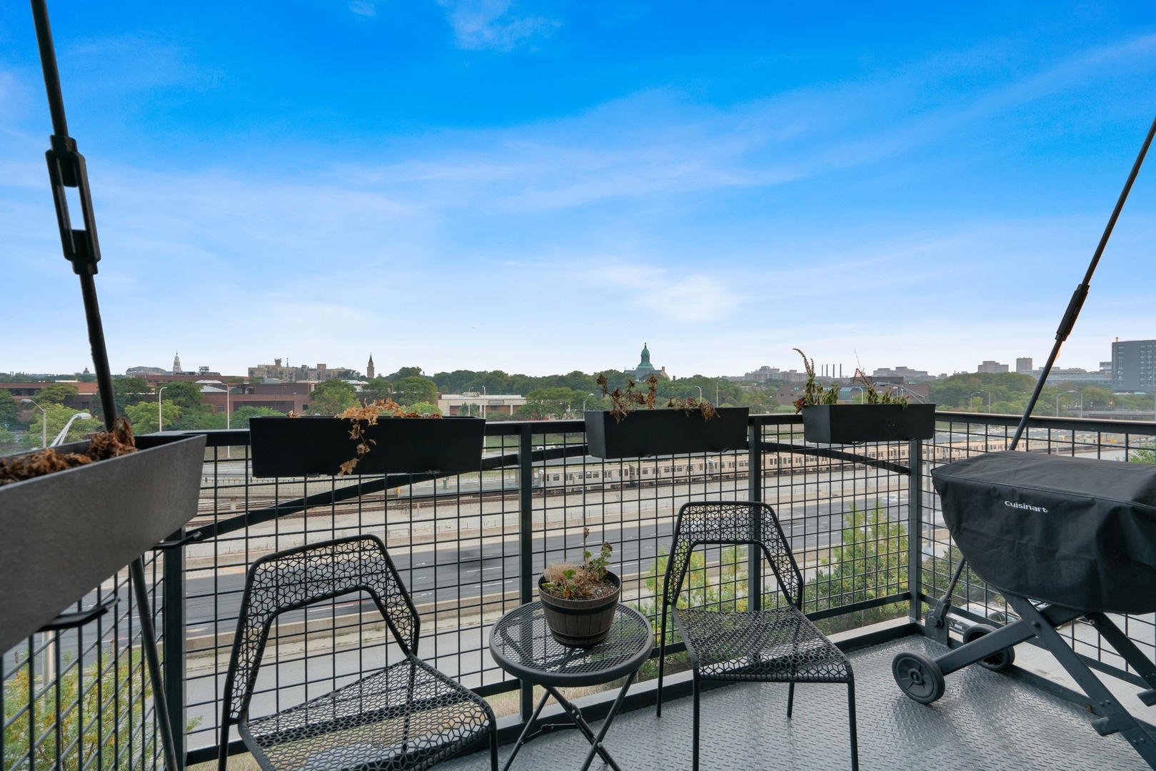 1224 West Van Buren Street, Unit 304 Chicago, IL 60607 - Photo 24 of 28 a view of a balcony with two chairs and a potted plant