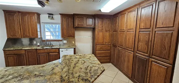 a kitchen with granite countertop stainless steel appliances a refrigerator and cabinets