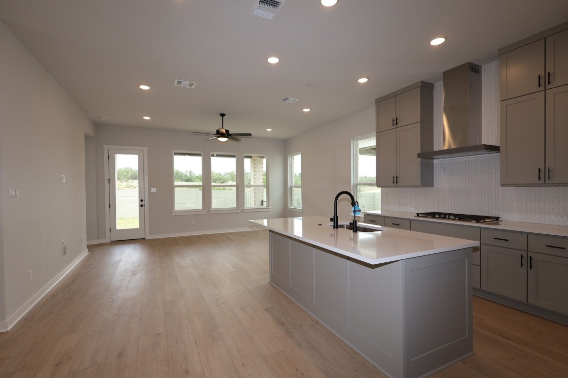 421 Leaning Rock Road Georgetown, TX 78628 - Photo 2 of 14 a kitchen with stainless steel appliances granite countertop a sink dishwasher a stove and a refrigerator with wooden floor