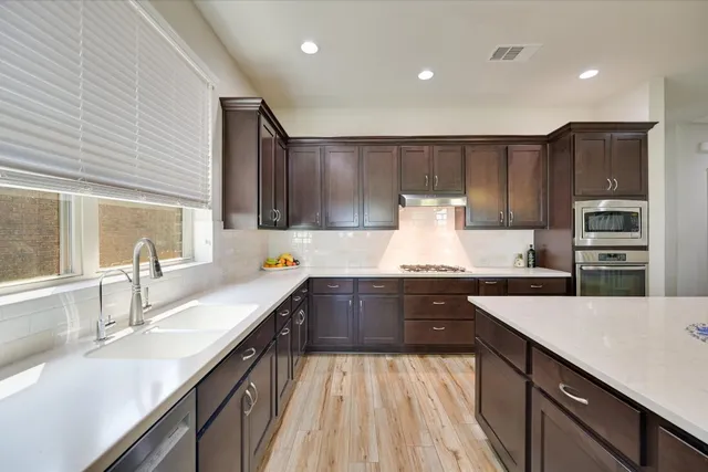 a kitchen with kitchen island granite countertop a sink counter top space appliances and cabinets