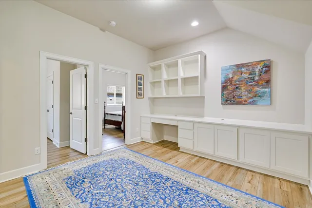 a view of a hallway with wooden floor and cabinet