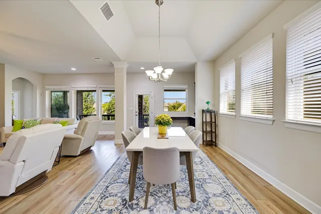 a view of a dining room with furniture a chandelier and wooden floor