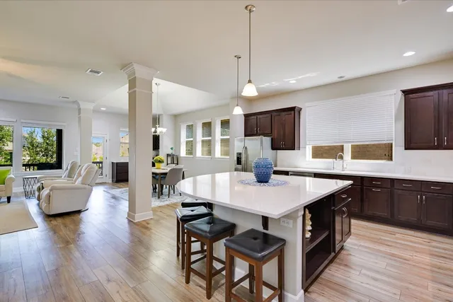 a large kitchen with kitchen island a island a stove a sink a dining table and chairs