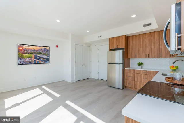 a view of kitchen with stainless steel appliances granite countertop a refrigerator and a sink