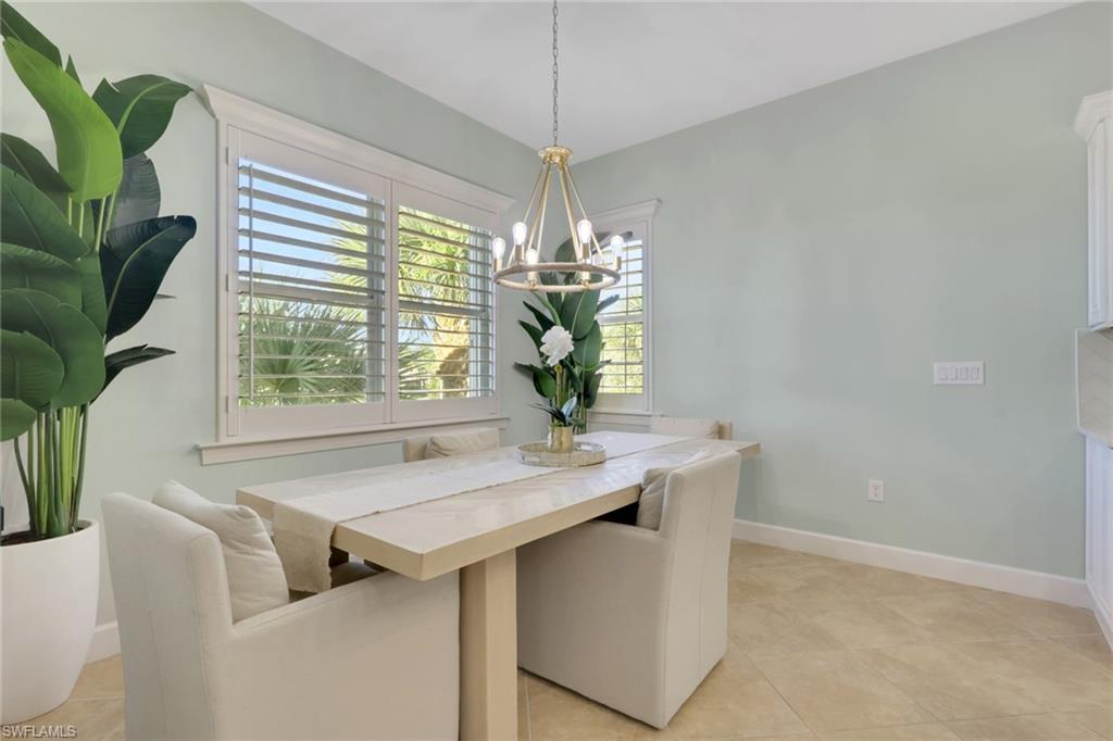 7877 Clemson Street, Unit 202 Naples, FL 34104 - Photo 13 of 36 a room with a table chairs and chandelier
