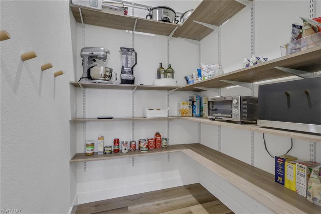 7877 Clemson Street, Unit 202 Naples, FL 34104 - Photo 14 of 36 a kitchen with white cabinets and window