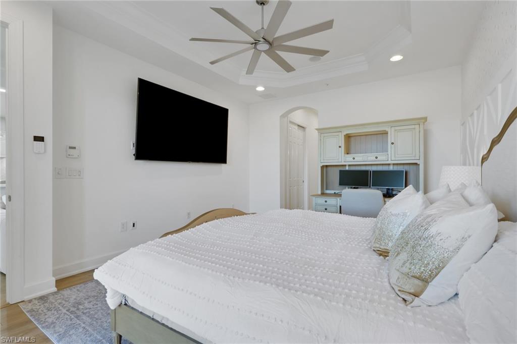 7877 Clemson Street, Unit 202 Naples, FL 34104 - Photo 17 of 36 a bedroom with a large bed and a flat screen tv