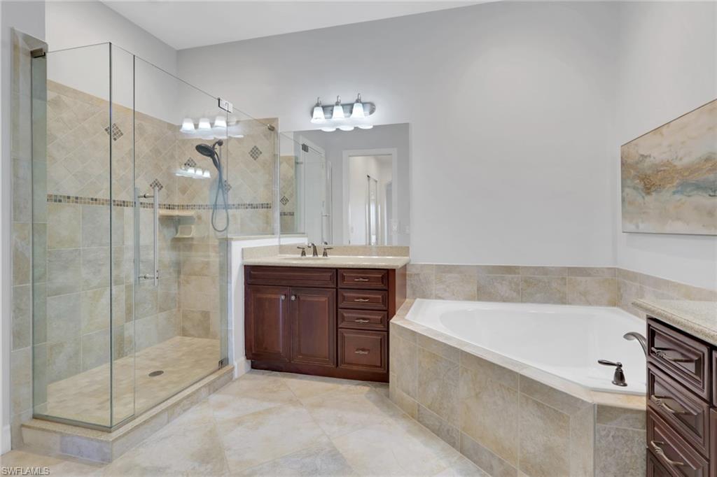 7877 Clemson Street, Unit 202 Naples, FL 34104 - Photo 19 of 36 a bathroom with a tub shower sink and mirror