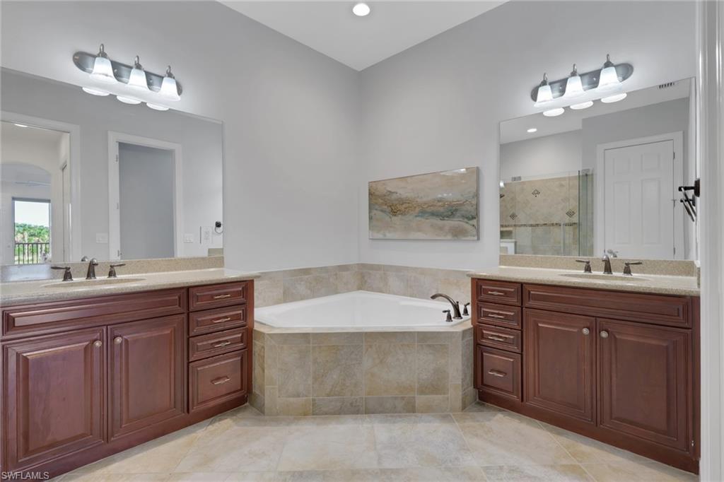 7877 Clemson Street, Unit 202 Naples, FL 34104 - Photo 20 of 36 a spacious bathroom with a tub double sink and mirror