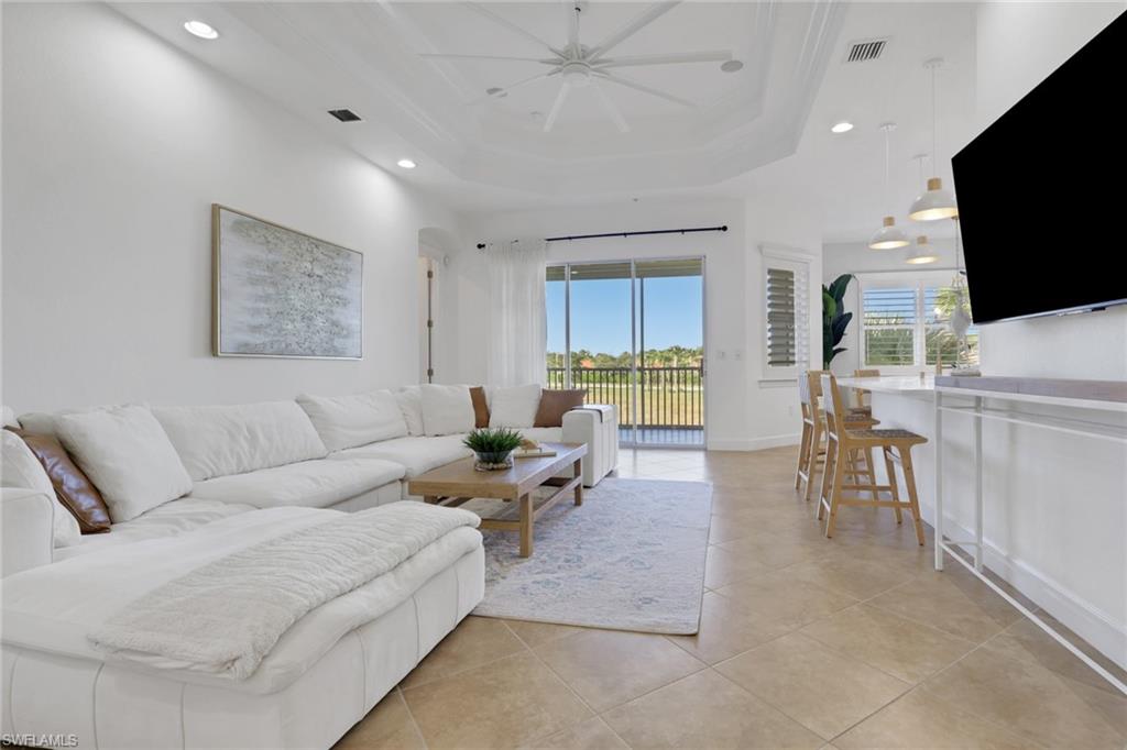 7877 Clemson Street, Unit 202 Naples, FL 34104 - Photo 2 of 36 a living room with furniture and a flat screen tv