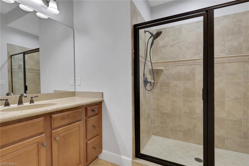 7877 Clemson Street, Unit 202 Naples, FL 34104 - Photo 25 of 36 a bathroom with a granite countertop shower sink and mirror