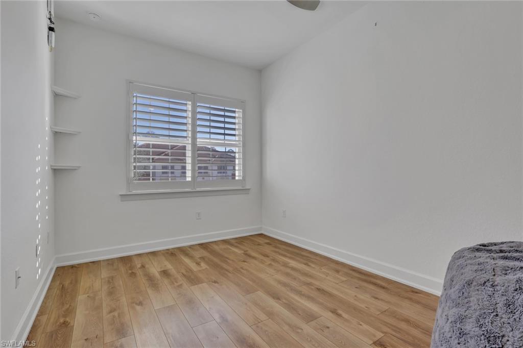 7877 Clemson Street, Unit 202 Naples, FL 34104 - Photo 28 of 36 a view of an empty room with wooden floor and a window